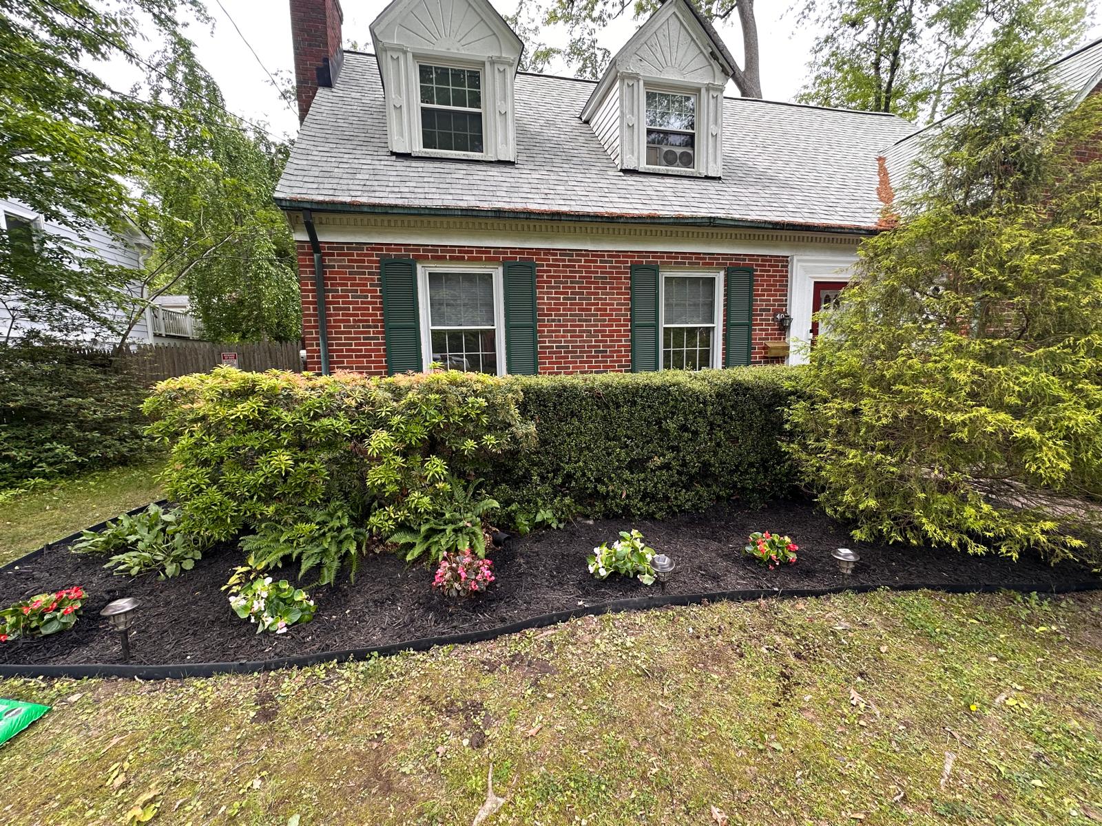 Landscaped front yard with flowers, shrubs and fresh mulch
