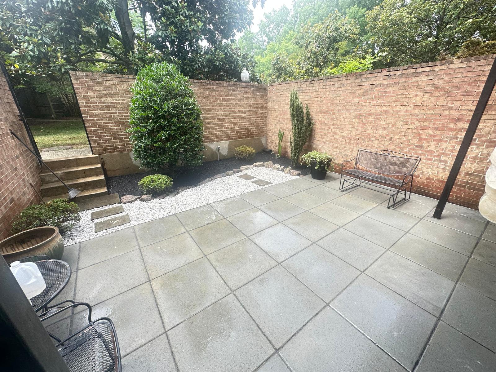 Finished courtyard patio with white stone walkway and landscaped beds